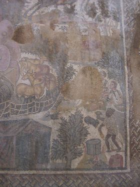 Mosaico della caccia (particolare): una verdeggiante piantumazione di palmeti e oliveti avvolge le scene integrandosi piacevolmente con i cavalli, carretti e animali
