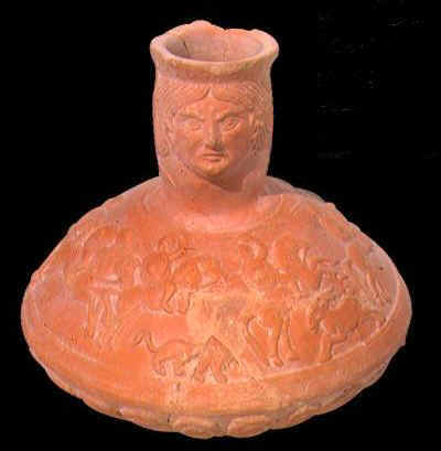 Vaso in ceramica sigillata che presenta il collo a forma di donna. L'ansa panciuta presenta delle scene di caccia. Il reperto risale al III sec. d. C.