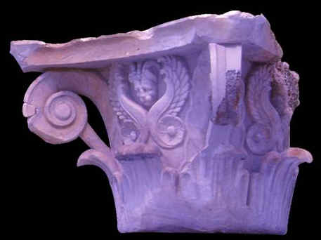 Capitello di stile atipico con decorazioni fatte di volute a palmette e maschere di grifoni. Il reperto proviene dagli scavi sottomarini ed è esposto al Museo del Bardo.