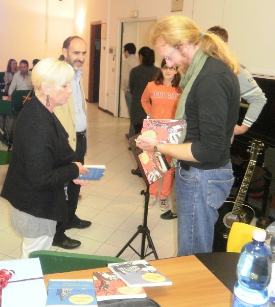 L'autore Gian Luca Alzati mentre autografa alcuni suoi libri