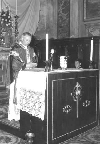 il parroco don Giovanni Motta nel presbiterio della parrocchiale 