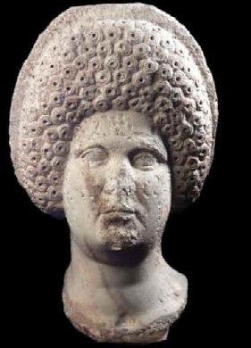 Testa di donna senza nome, senz'altro una semplice popolana. La sua acconciatura sembra un nido d'api ed  per lo meno originale. Datazione incerta. Attualmente  al Museo del Bardo