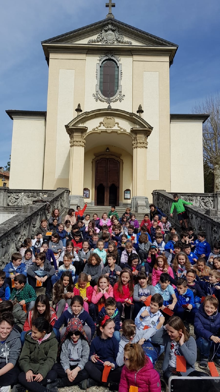Un bel gruppo di ragazzi seduti lungo la scalinata della chiesa parrocchiale di Cassago