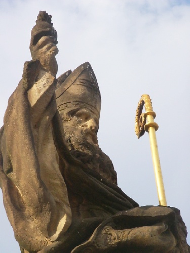 Agostino vescovo alza al cielo il cuore fiammante: statua sul ponte Karlova a Praga