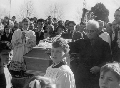 Don Enrico Colnaghinella bara in cimitero: in primo piano il fratello.Sulla sinistra il chierico don Ambrogio Giussani